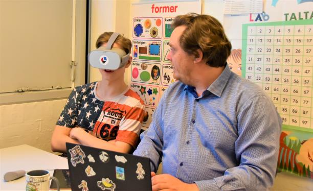 Skoleelev fra Bakkeskolen prøver virtual reality briller for at styrke sin mentale sundhed. Ved siden af eleven sidder læreren og følger med i det, elever ser i VR-brillerne